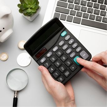 Calculator with coins and piggy bank on desk